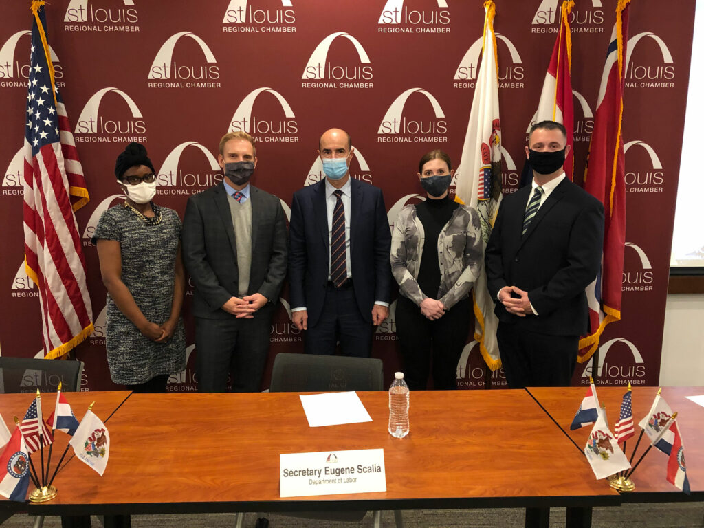Secretary Eugene Scalia photographed with group wearing masks in front of St Louis regional Chamber panel.