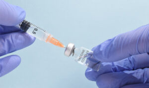 Medical professional preparing a vaccine syringe.