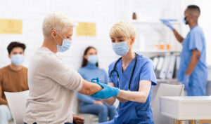 Medical professional giving woman a vaccine.
