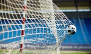 A soccer ball flies into a net