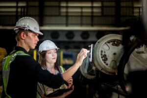 Two factory engineers inspect a machine